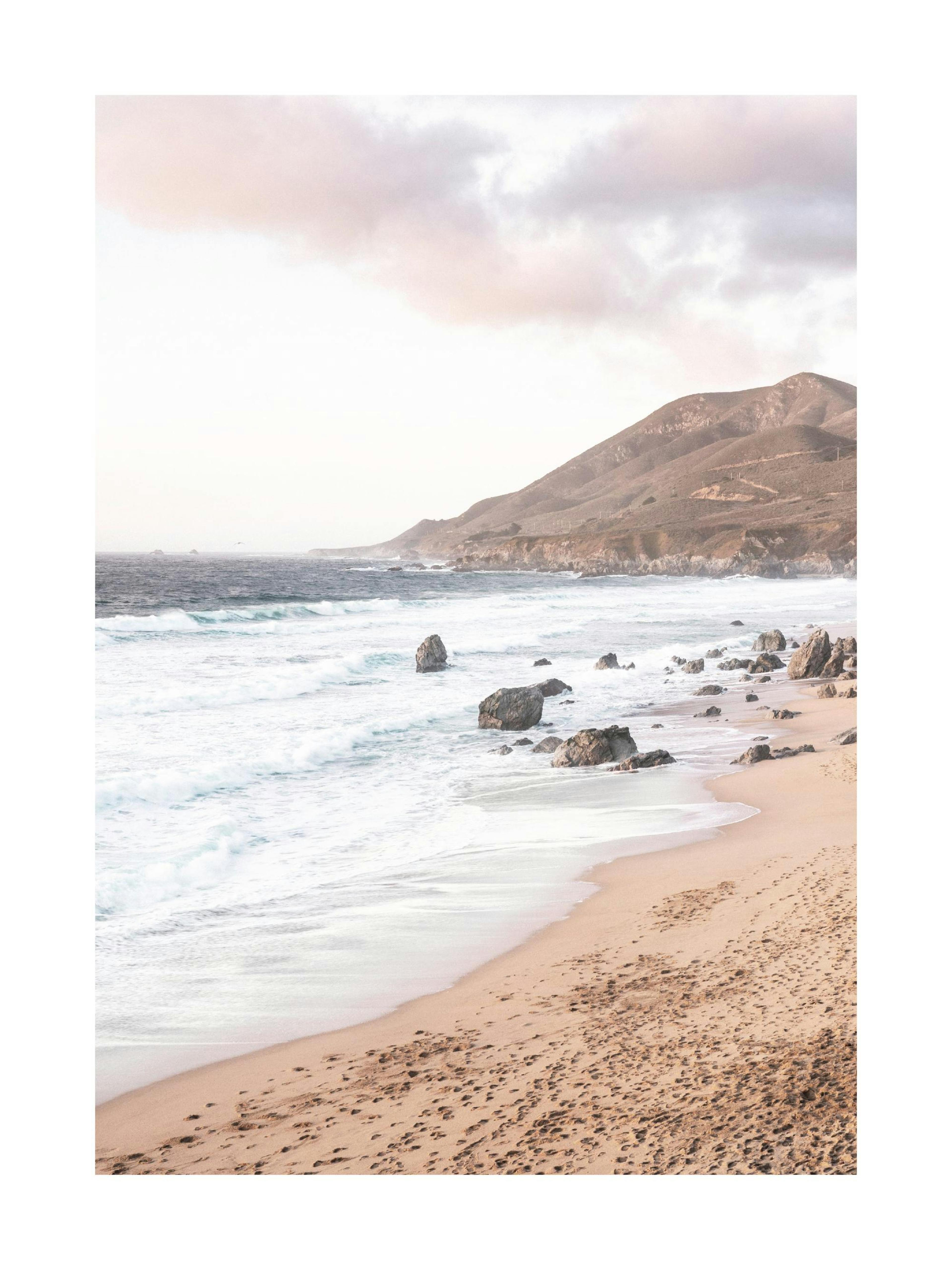 Plakat przedstawiający piaszczystą plażę z wzburzonymi falami oceanu, skalistym brzegiem i górami w tle.