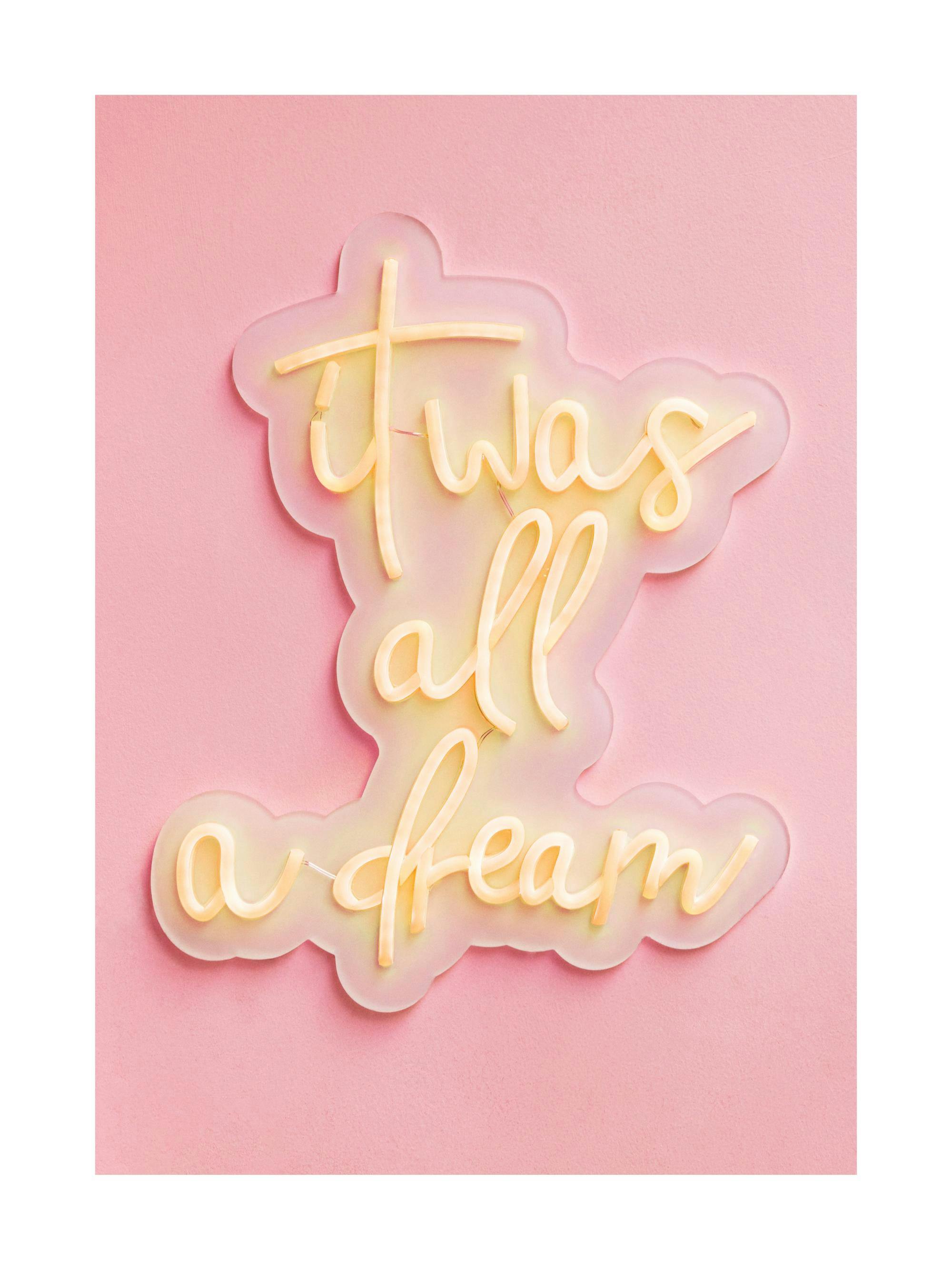 Ein Poster mit einer neonfarbenen Leuchtschrift It was all a dream auf transparentem Hintergrund, umgeben von einem pinkfarbenen