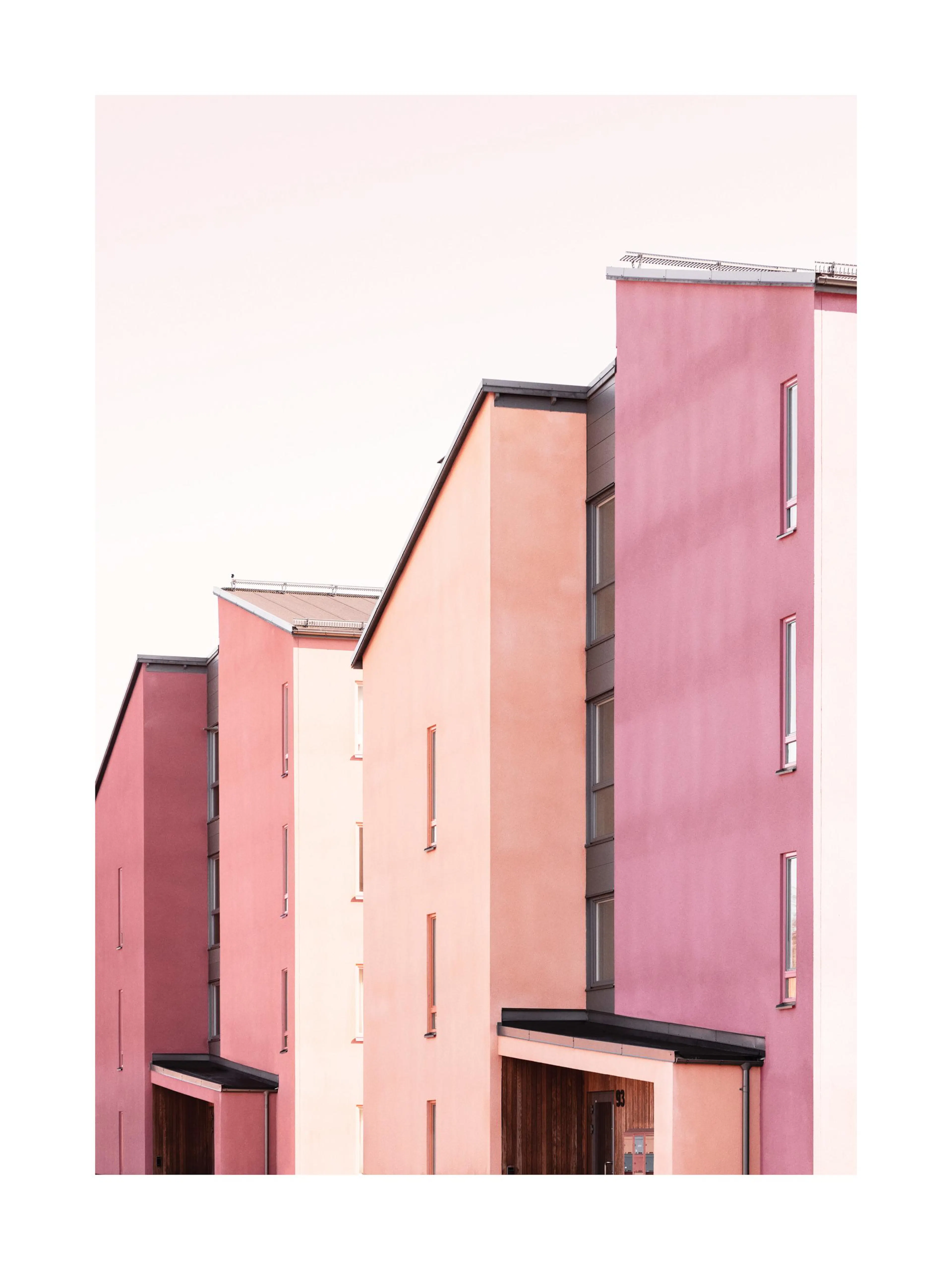A poster featuring a minimalist architectural view of buildings with pink and peach facades under a bright sky.