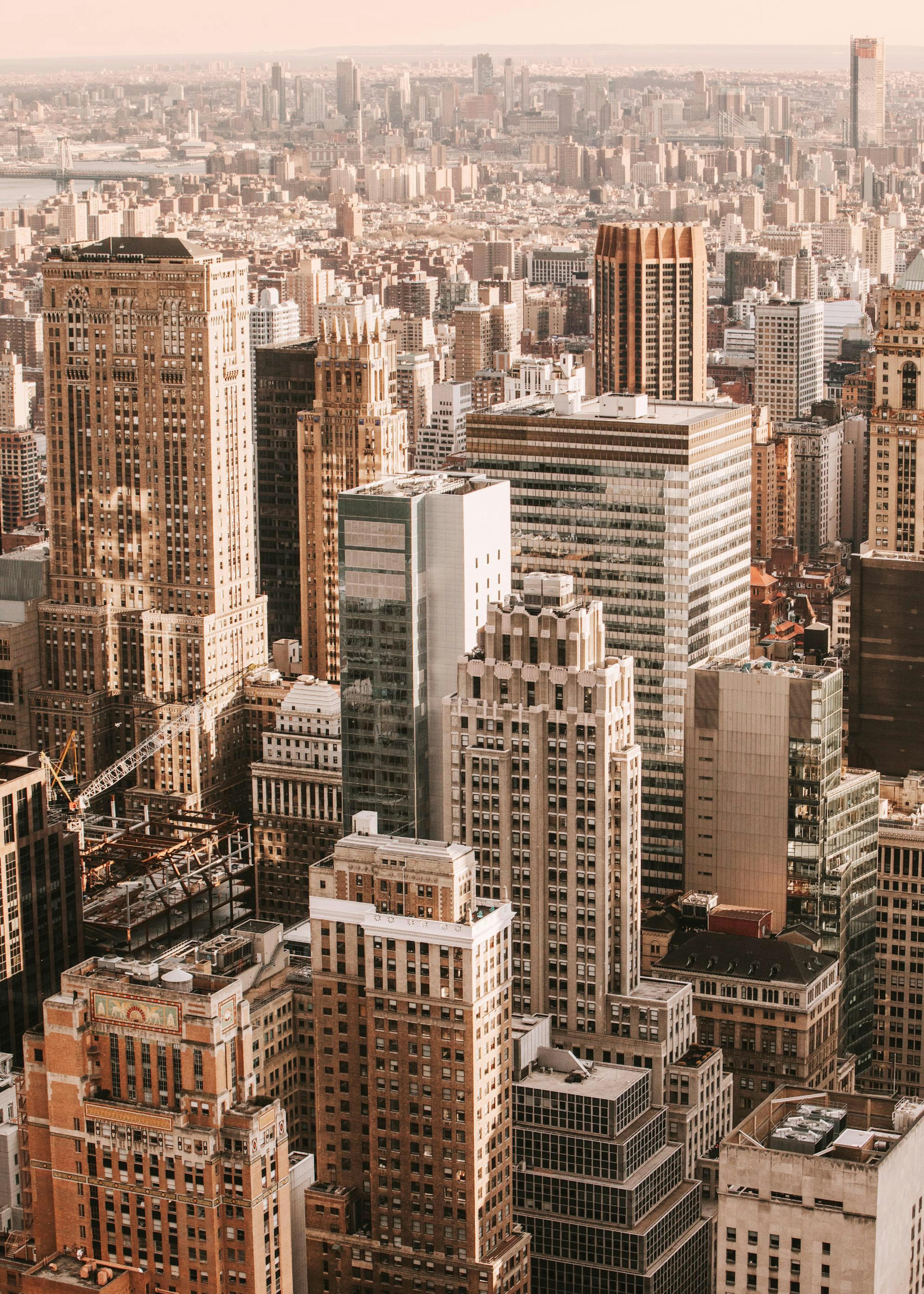 A poster displaying an aerial view of a city with tall buildings, hanging above a bed in a modern bedroom.
