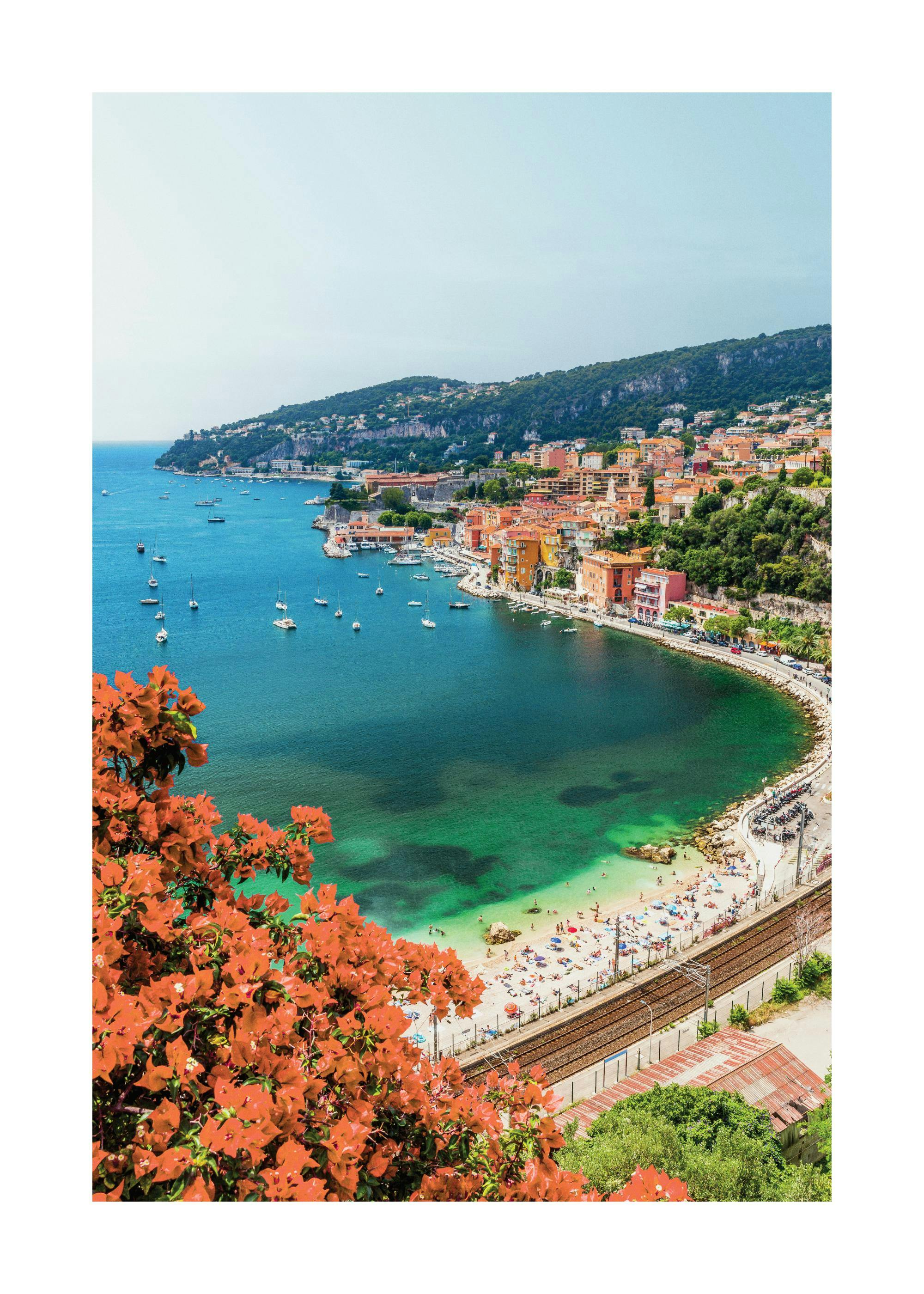 A poster featuring a vibrant coastal town with colorful buildings, a busy beach, and boats in a turquoise bay, seen through oran