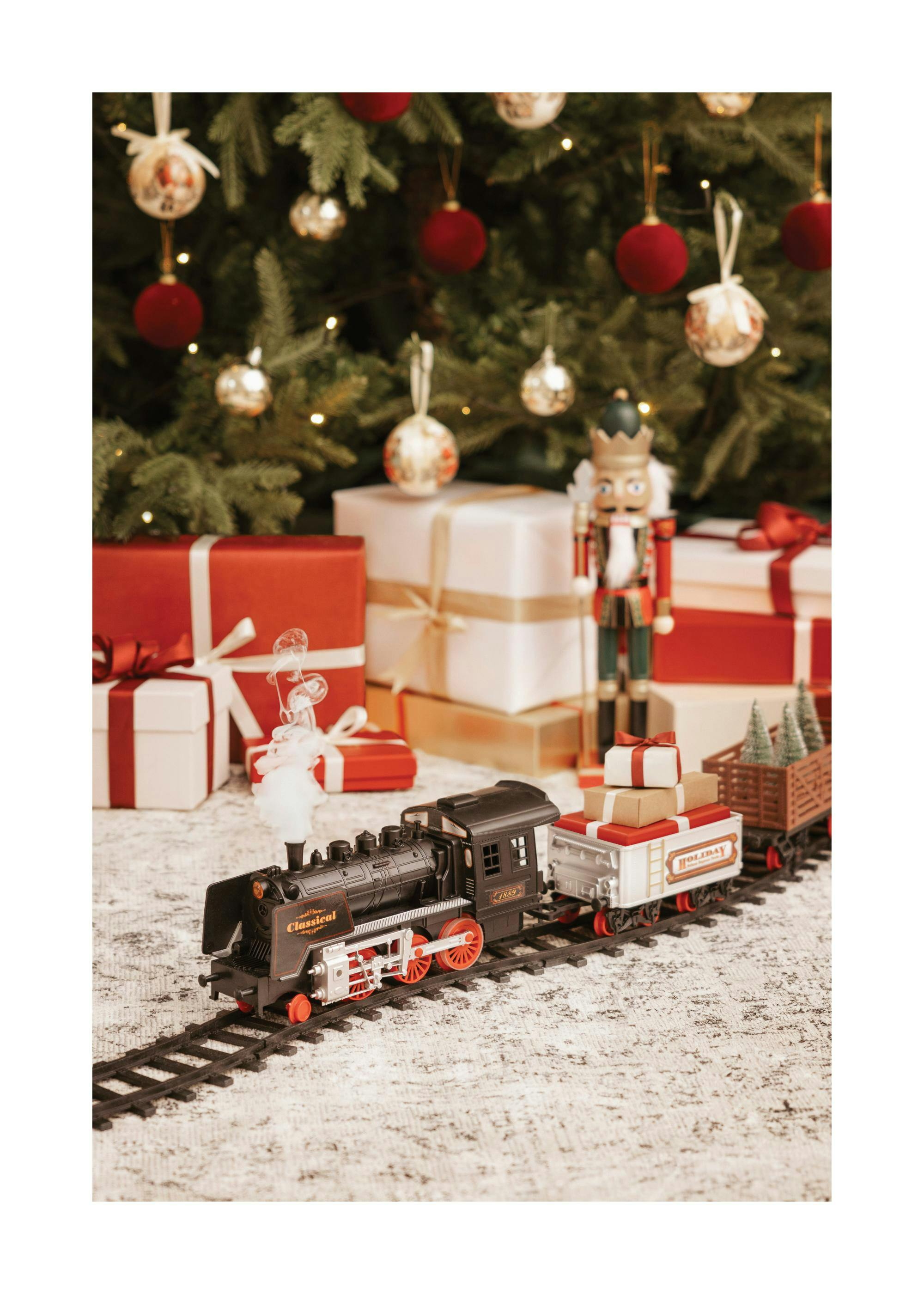 A festive Christmas poster featuring a toy train with presents and mini trees, with a decorated Christmas tree and gifts in the