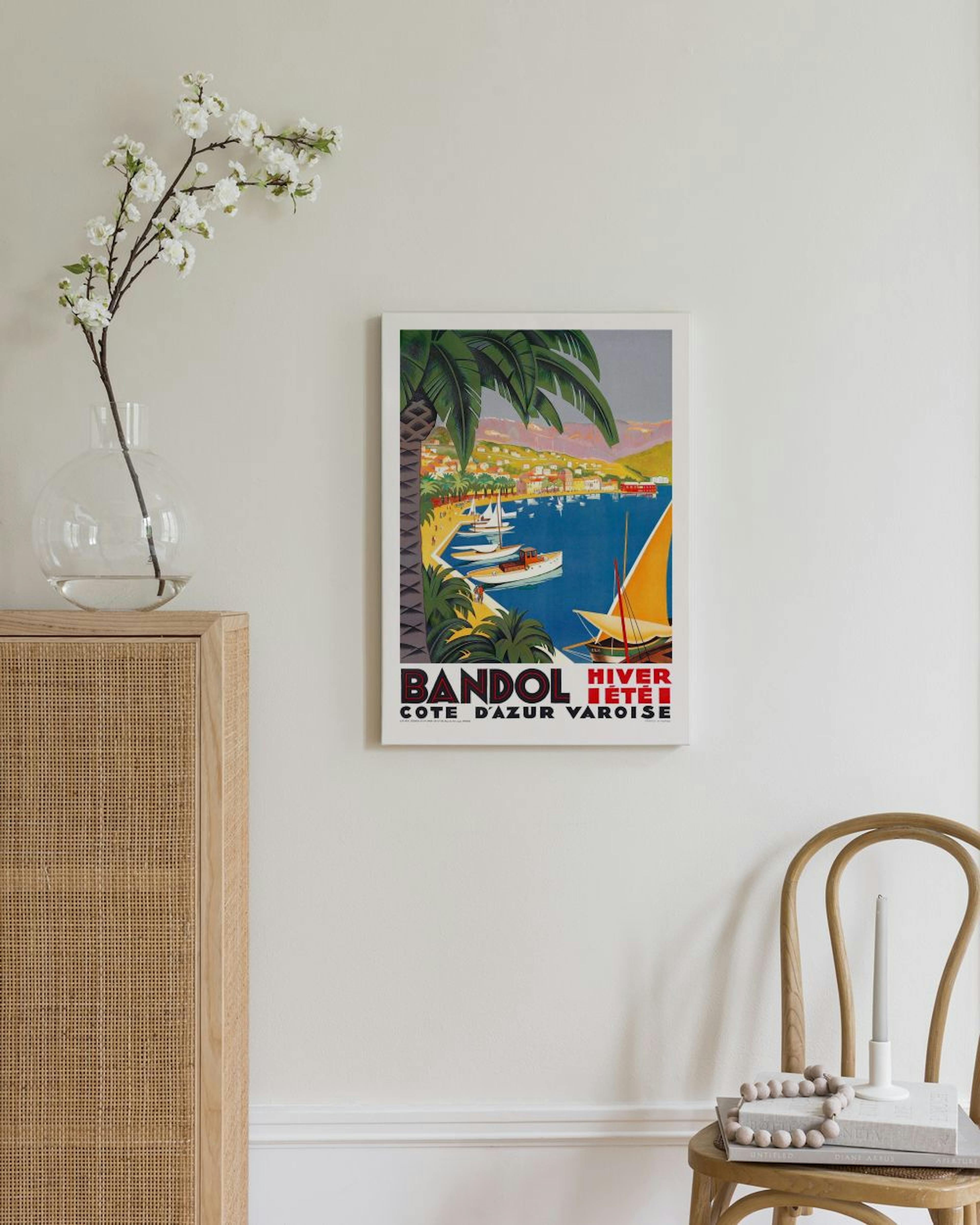Vintage tyylinen juliste Bandol-kaupungista, jossa on sininen merenlahti ja veneitä, ripustettuna vaalealle seinälle.