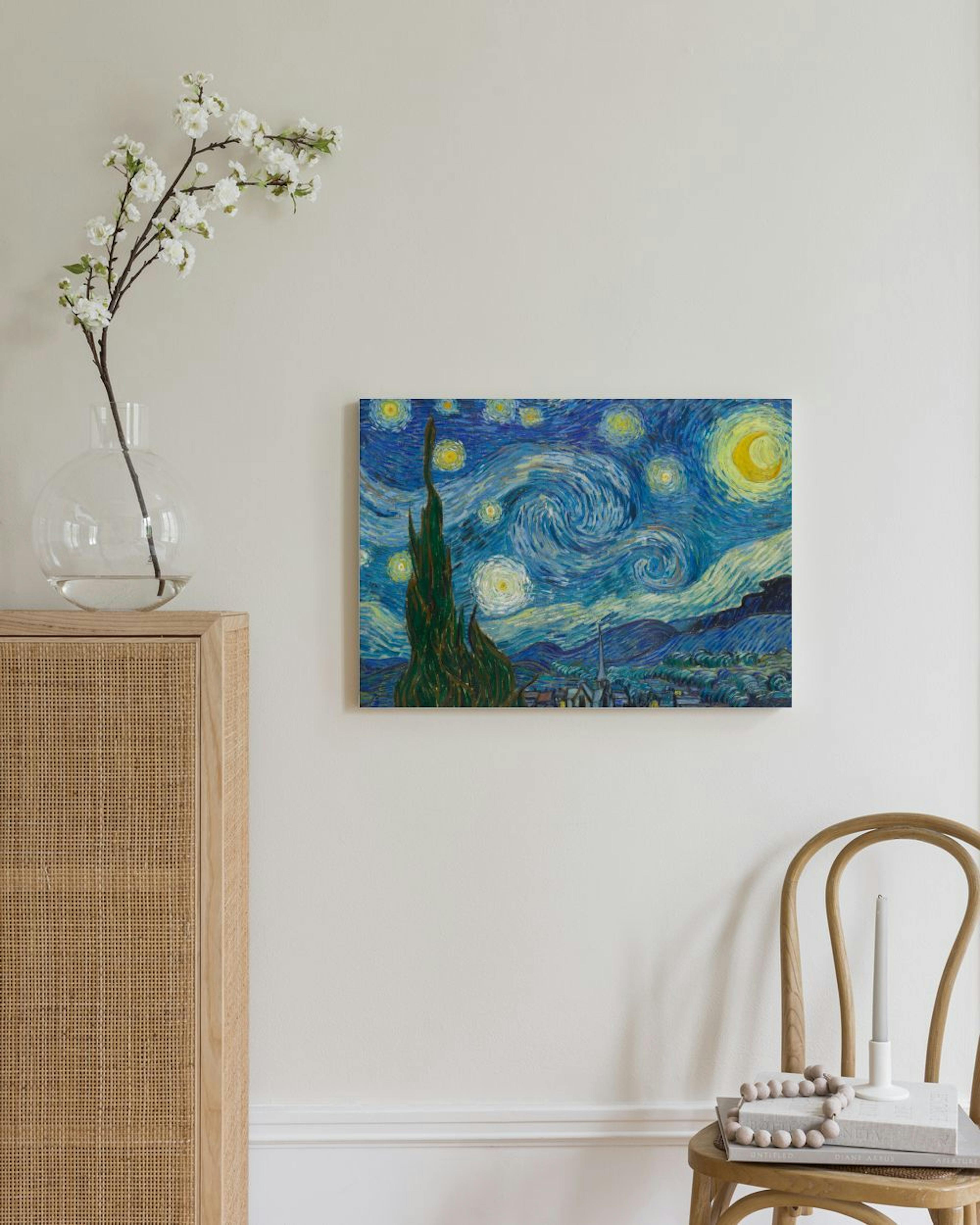 Kanvaasi esittää Van Goghin Tähtiyön. Teos on esillä valkoisella seinällä, rottinkikaapin ja puutuolin välissä.