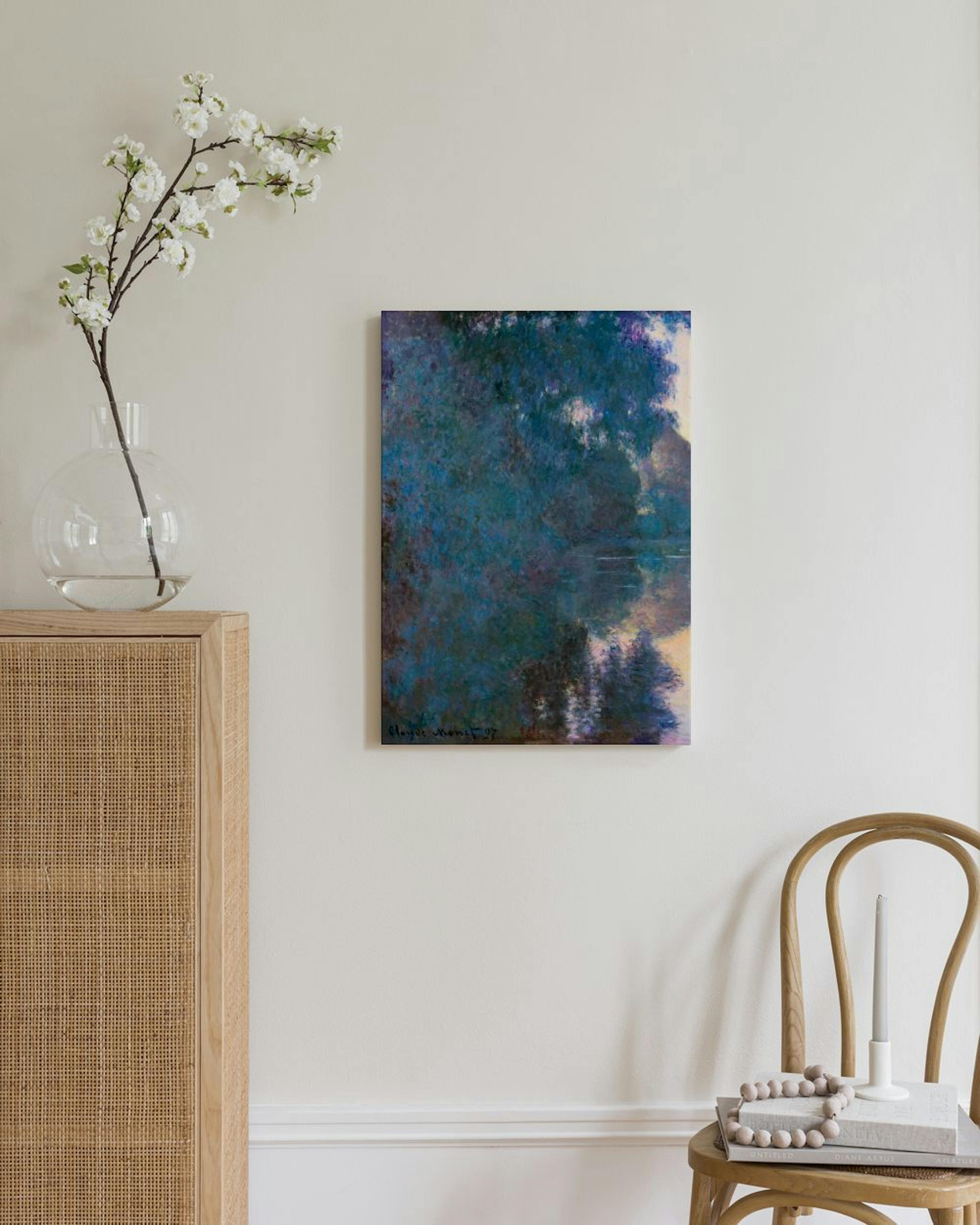 Monet-kanvaasi, jossa sinivihreä järvimaisema heijastuu veden pinnasta. Kanvaasi on esillä vaaleassa huoneessa, jonka nurkassa o