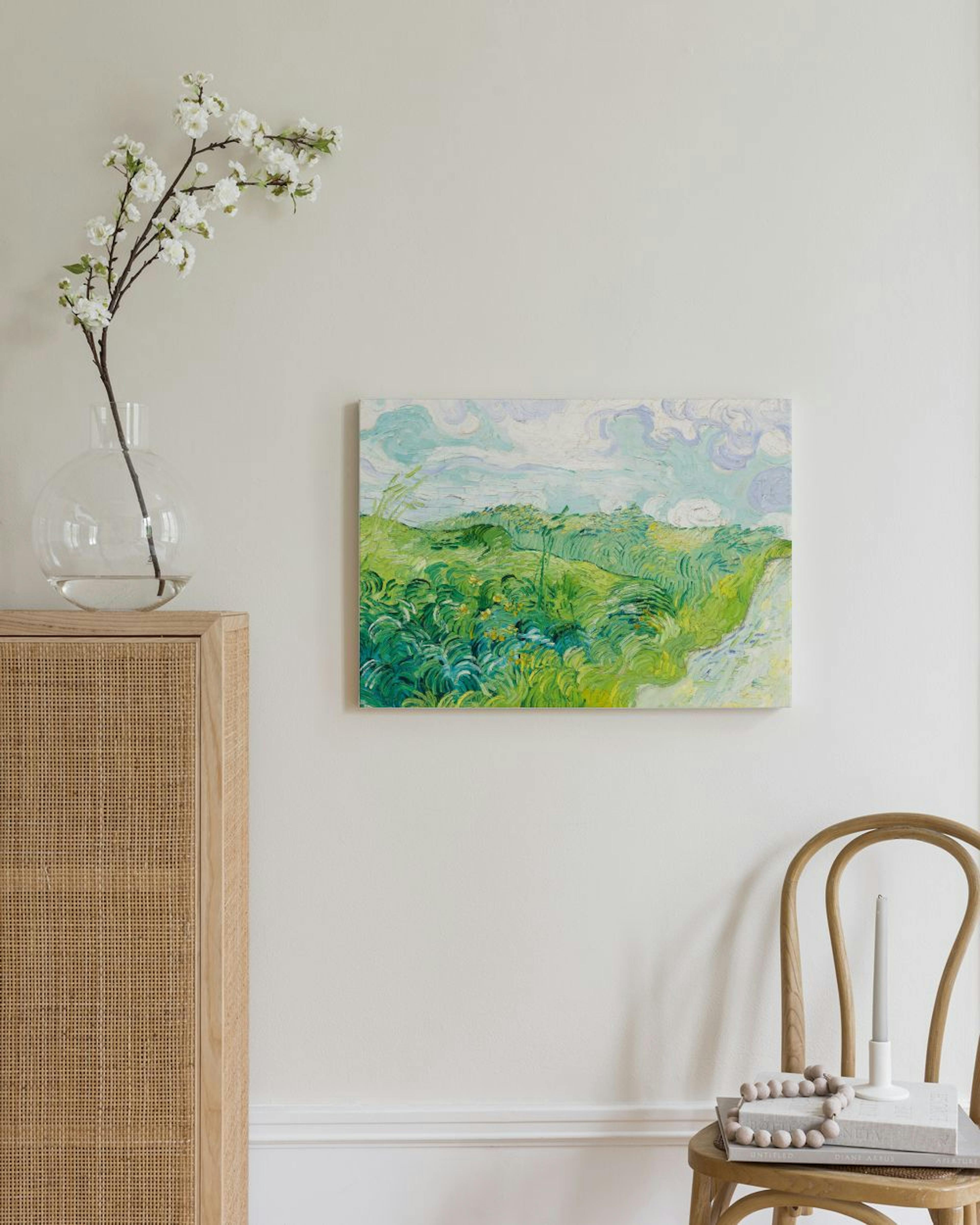 Van Goghin maalaus vihreästä vehnäpellosta ja sinitaivaasta roikkuu vaalealla seinällä modernissa huoneessa.