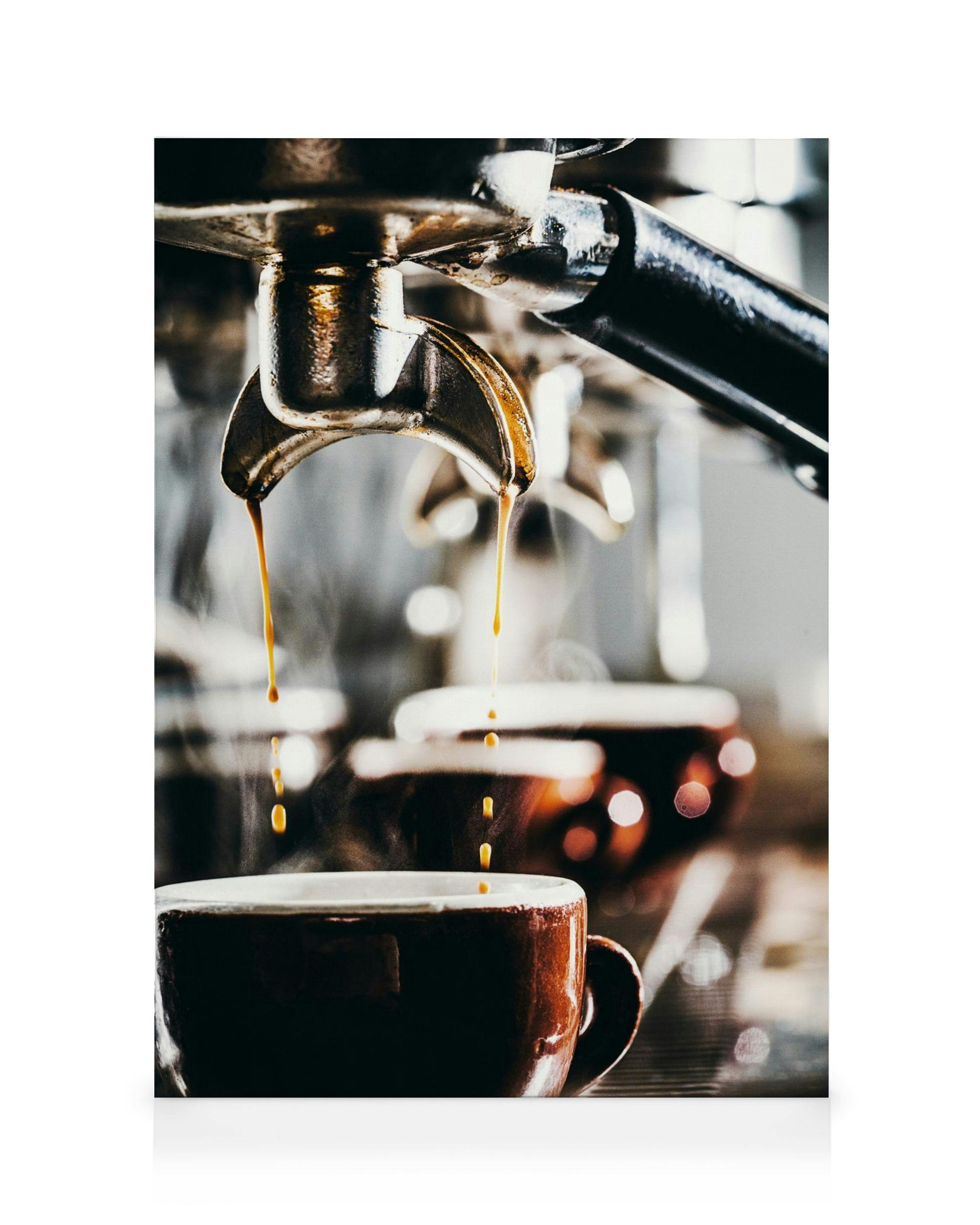 Kanvaasi, jossa espressokoneesta valuu kahvia ruskeaan kuppiin höyryn noustessa. Taustalla lisää sumeita kahvikuppeja.