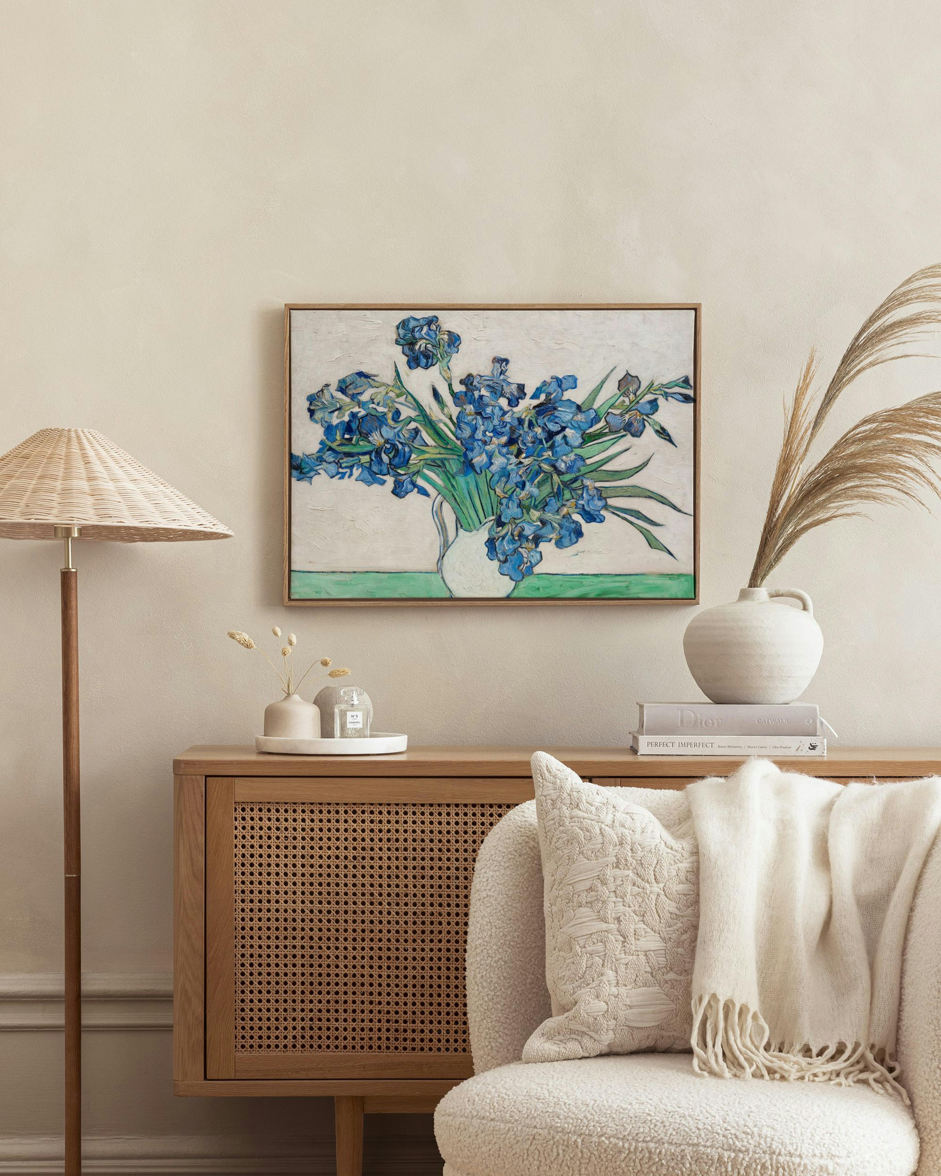 Van Gogh Íriszek festménye vászonképen, egy modern szobában, fonott szekrény és szék mellett.