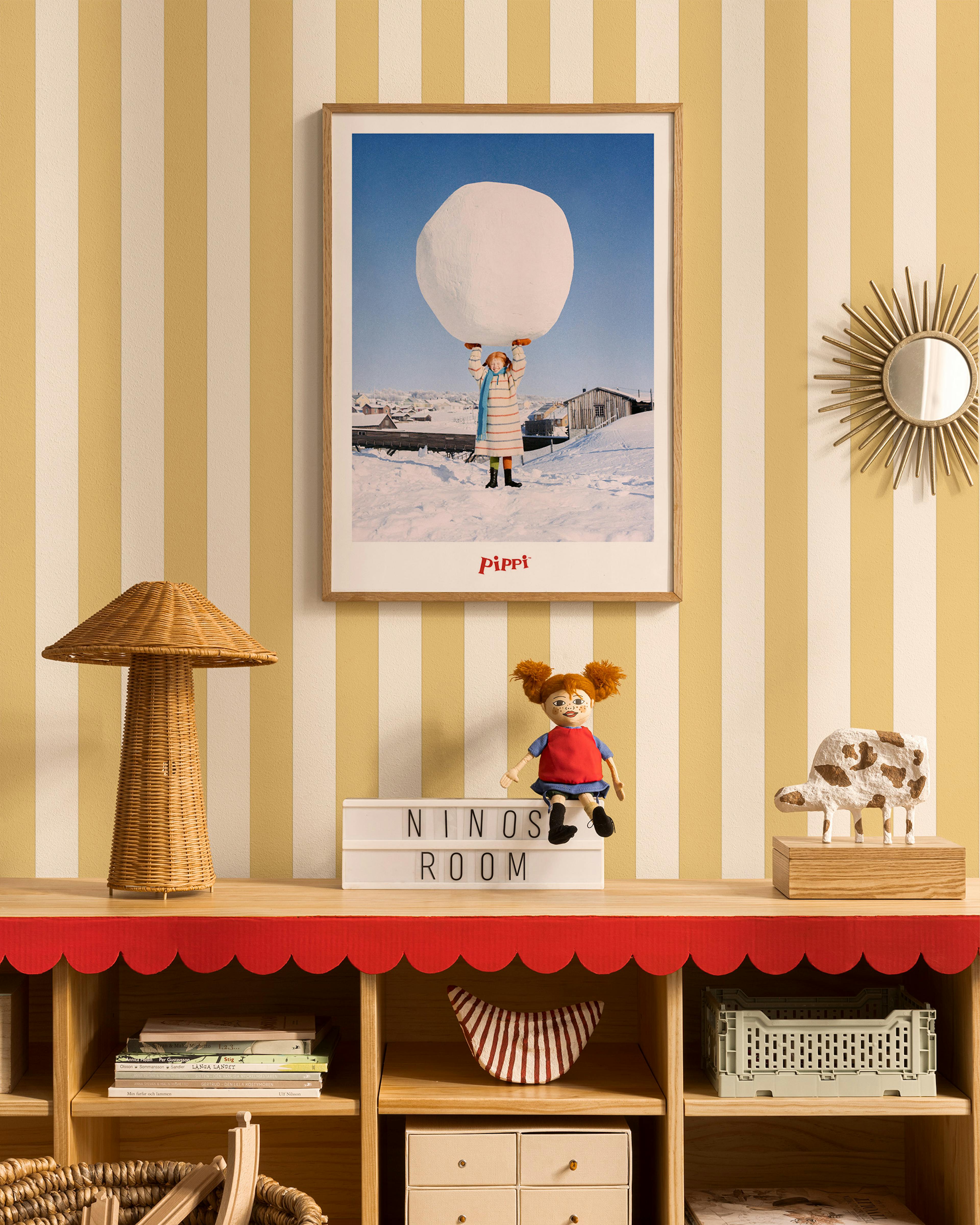 A colorful childrens poster with a man and child on a checkered background, hanging in a childs room above a wooden shelf.