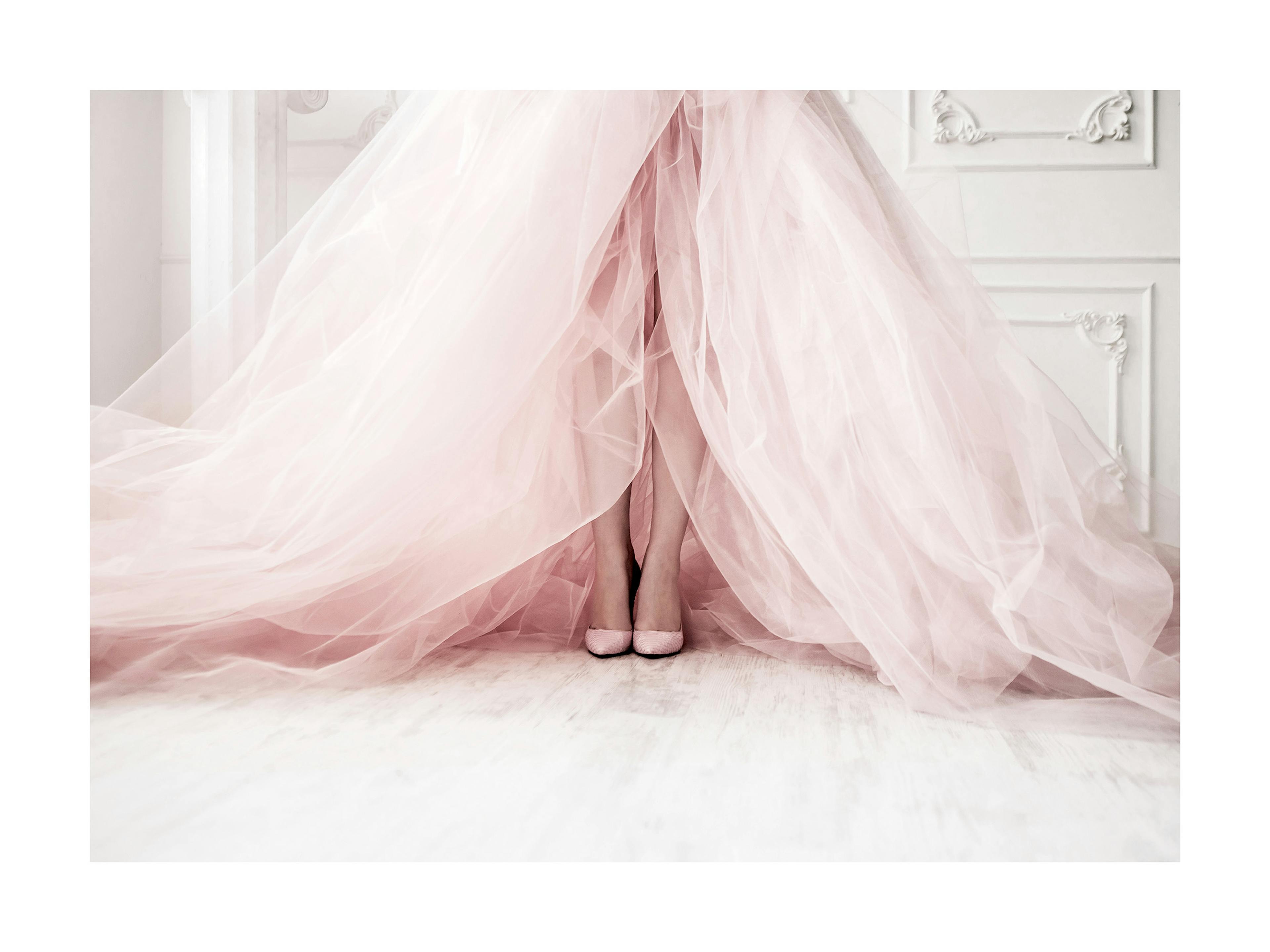 Póster de dos pies con zapatillas rosadas de ballet, cubiertos por tela vaporosa rosa pálido.