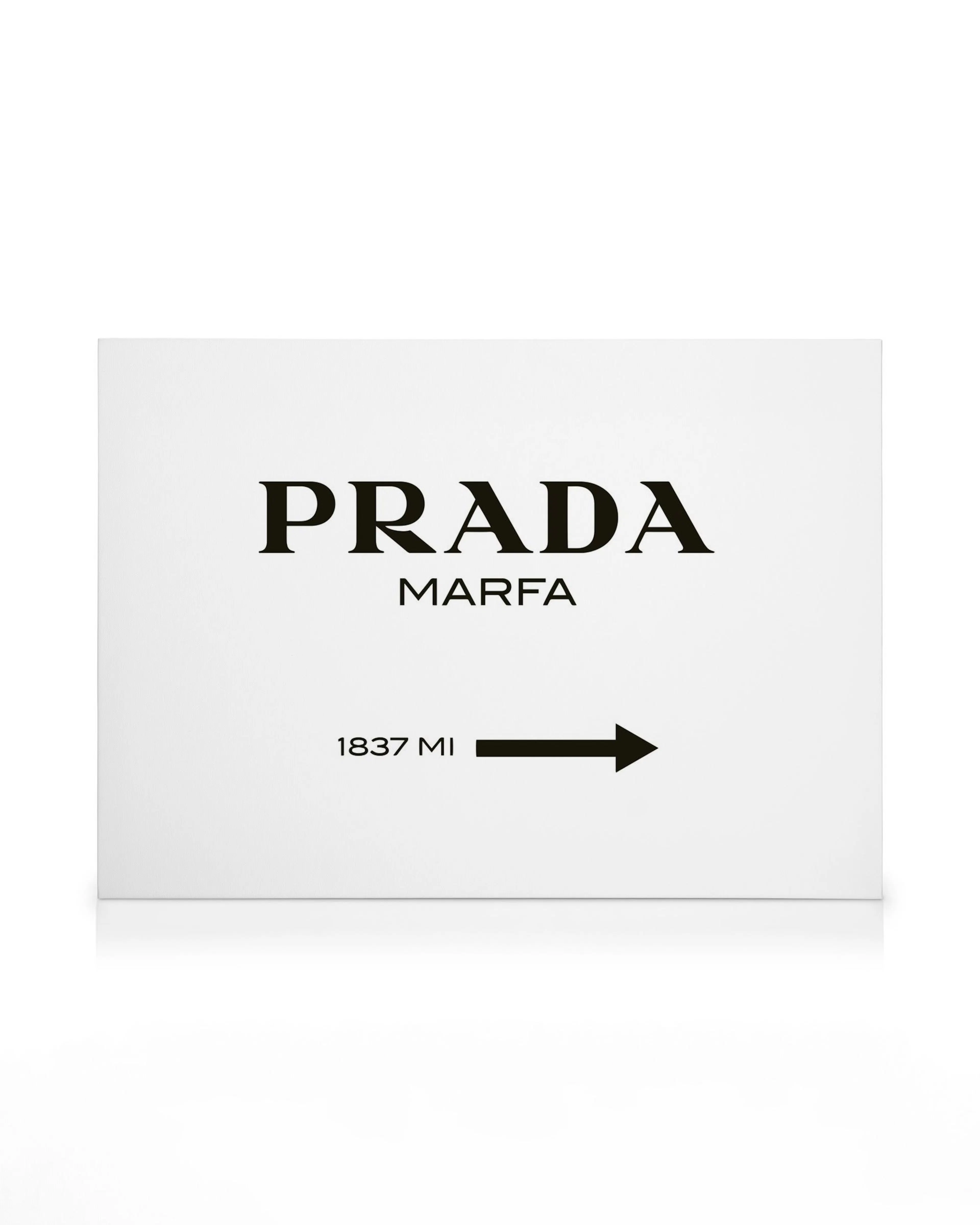 Obraz na plátně s černým nápisem PRADA Marfa a šipkou s textem 1837 MI na bílém pozadí.