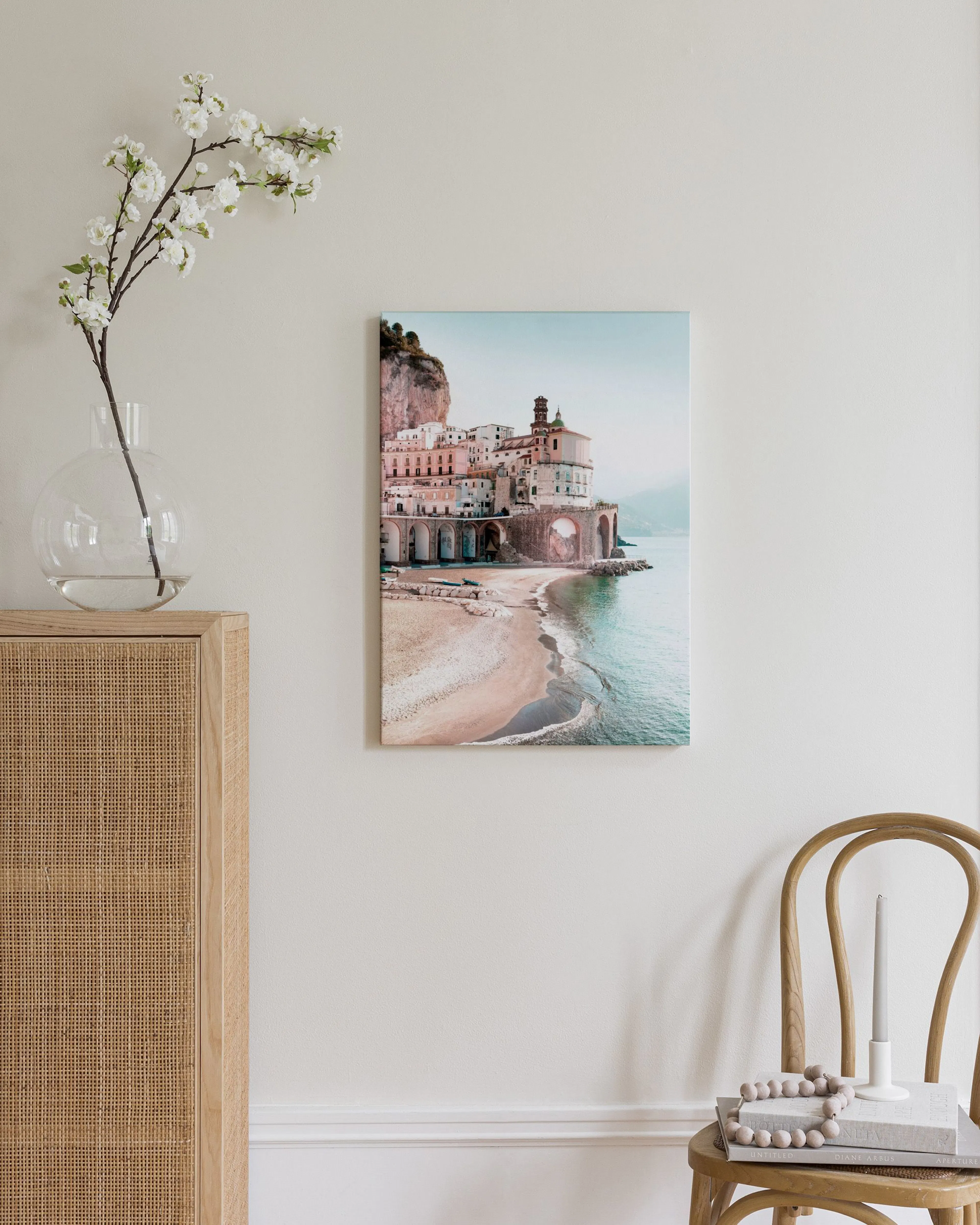 Canvas van de Amalfikust met het stadje Atrani aan een strand, boven een wit poefje met deken.