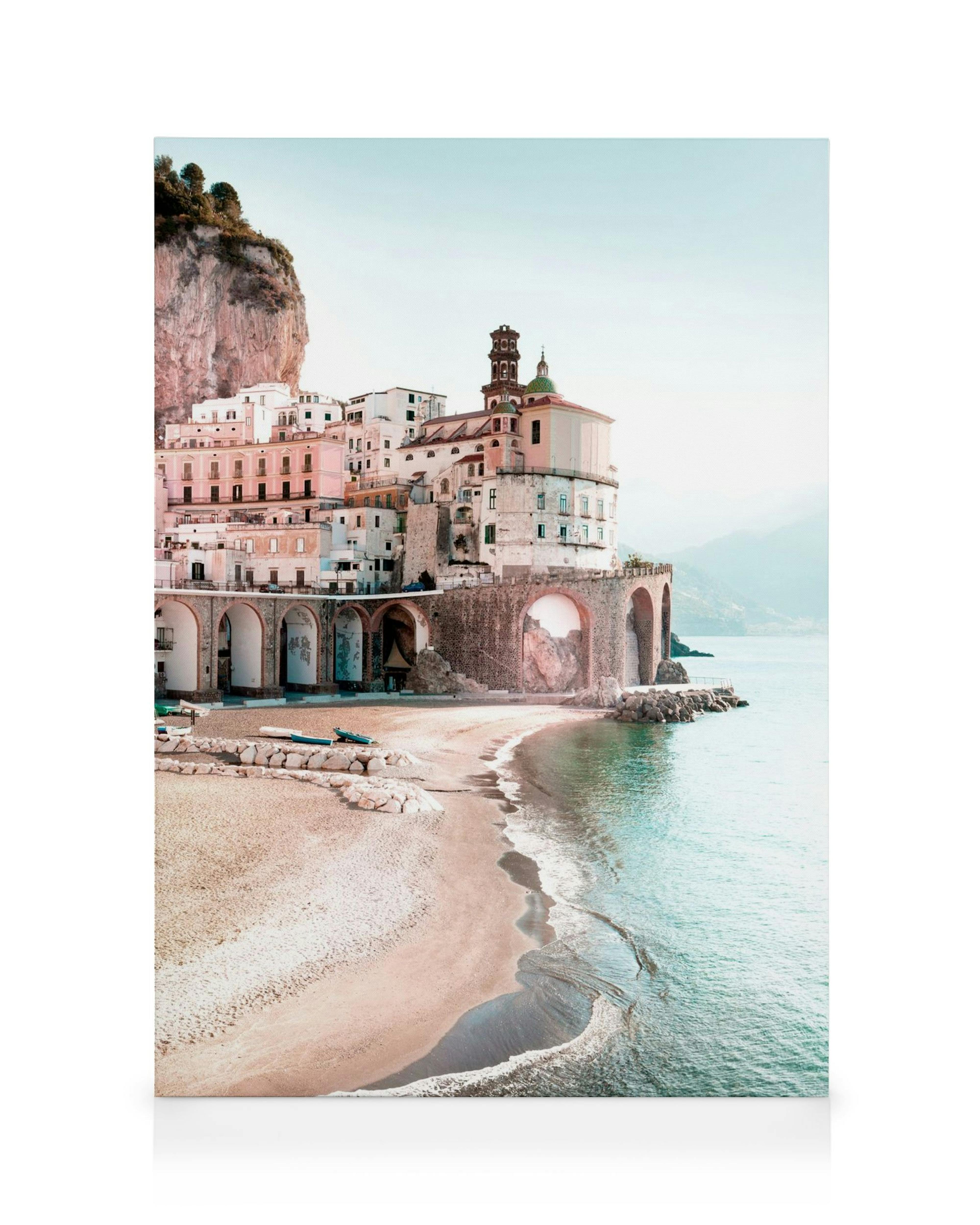 Obraz na płótnie przedstawiający brzeg morza z piaskiem i turkusową wodą, z miastem na klifie w tle.