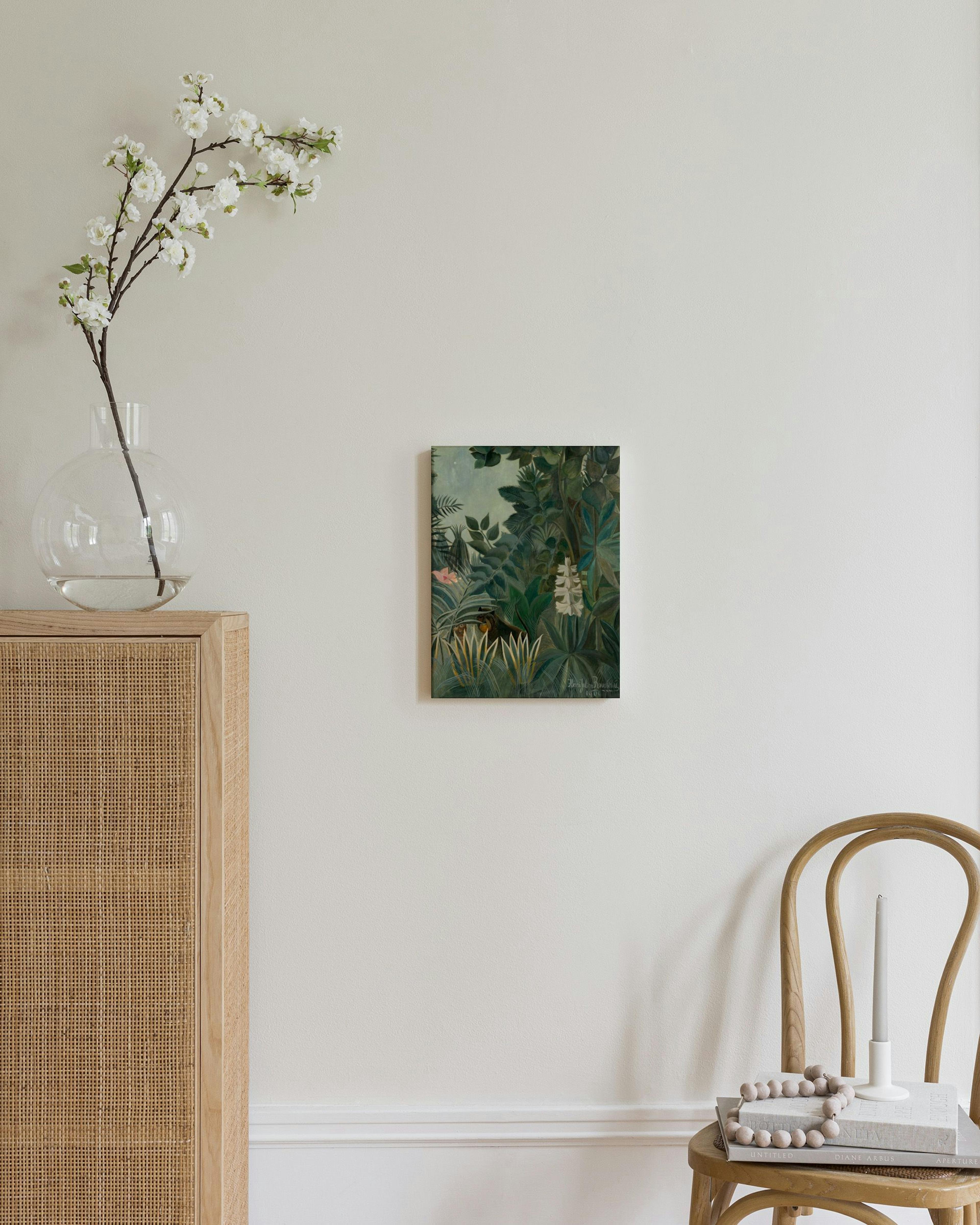 Schilderij van een jungle met dichte groene bladeren, roze bloemen en een glimp van een dier, hangend in een moderne kamer.