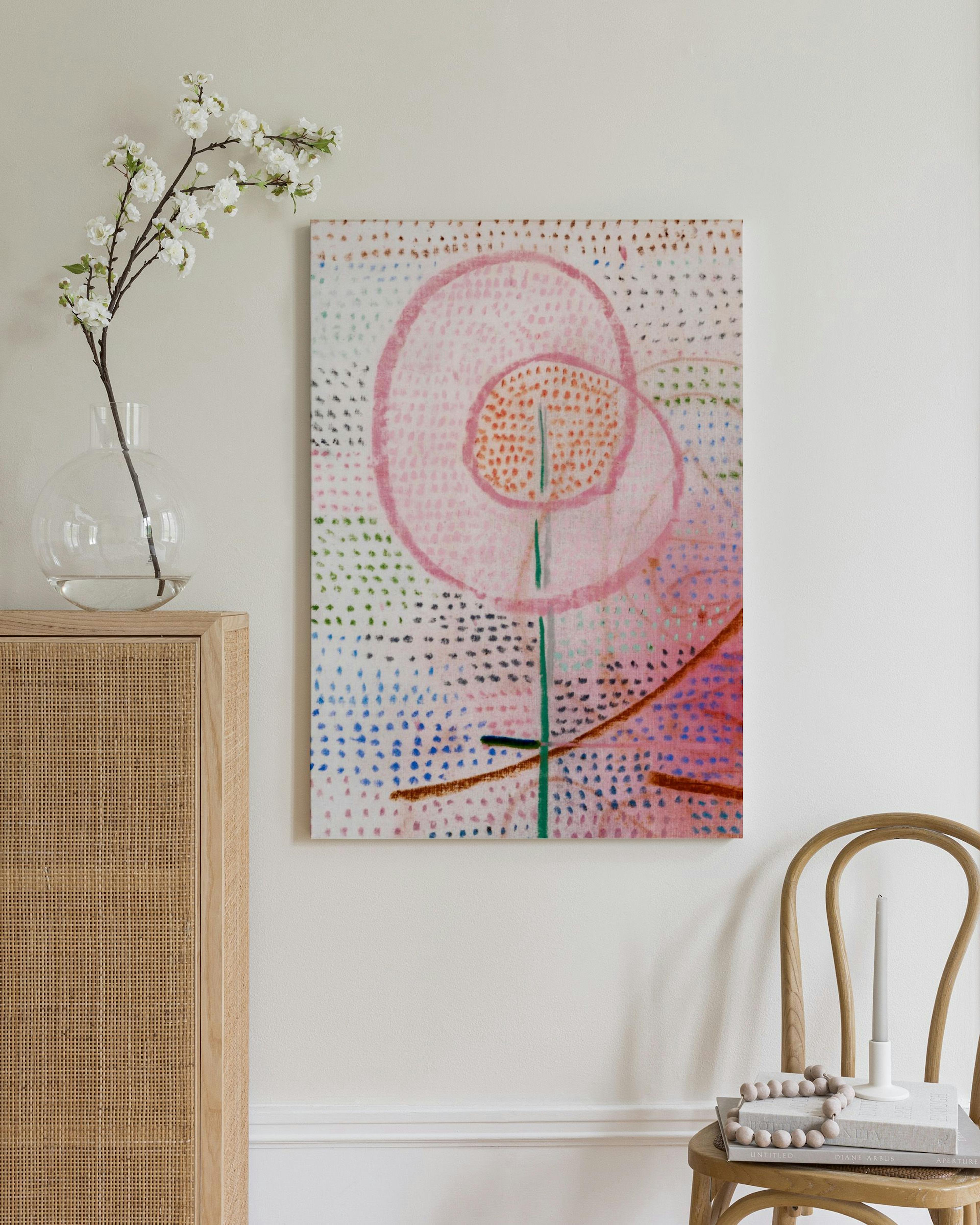 A canvas print with a pink abstract flower on a textured white background with colorful dots.