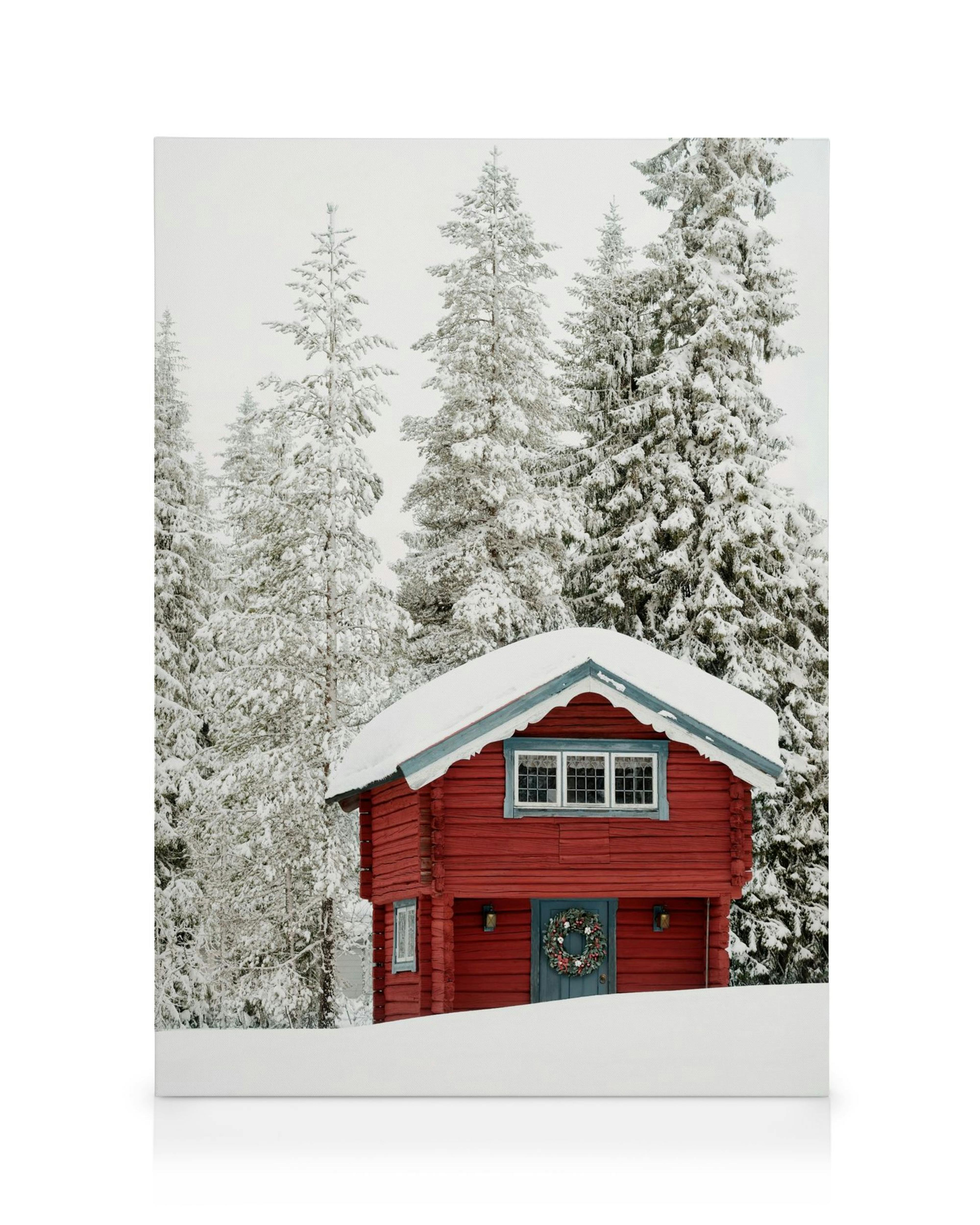 A canvas showing a red wooden cabin with a wreath on the door, surrounded by snow-covered pine trees and a white landscape.