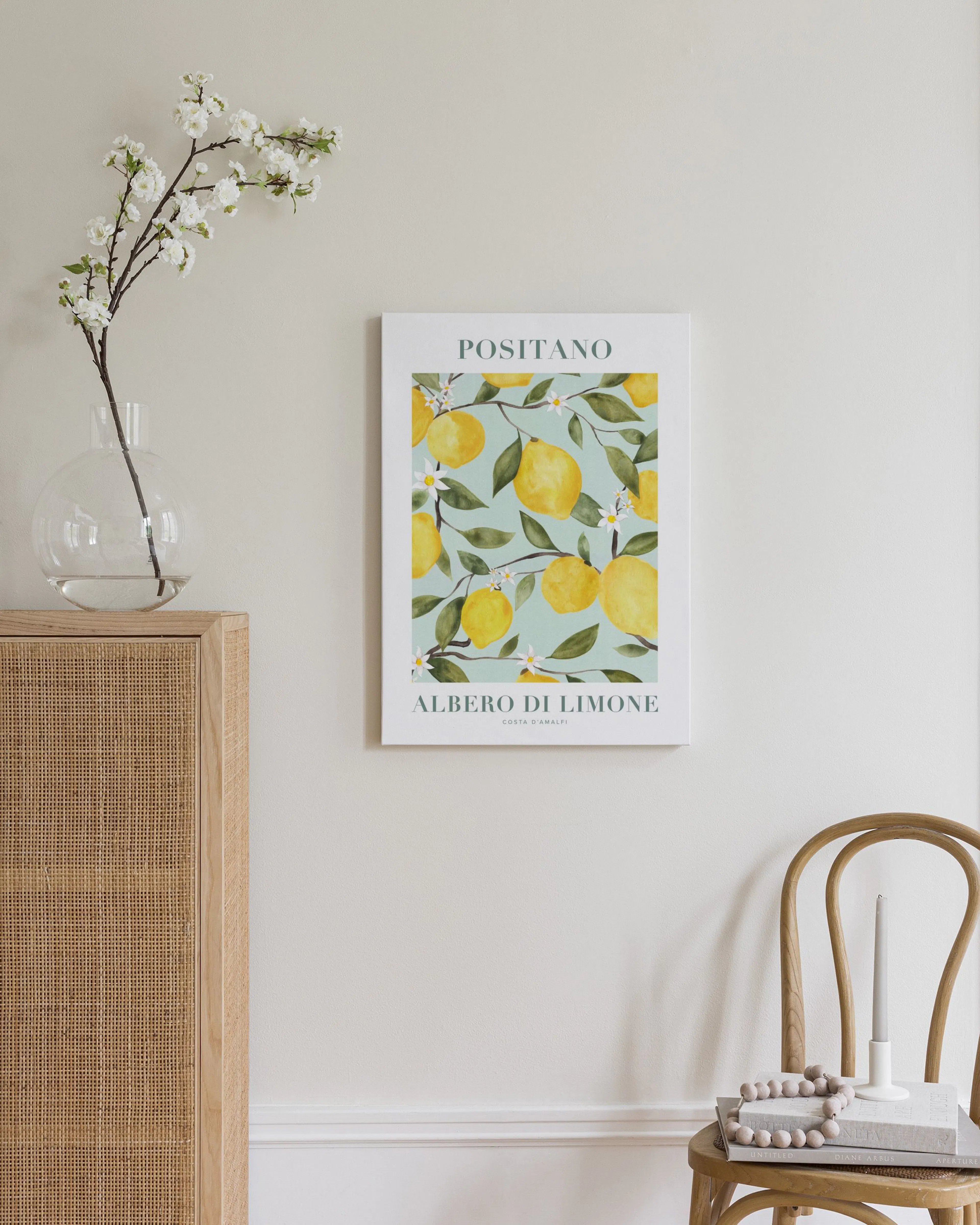 Toile Positano Albero di Limone avec citrons jaunes et fleurs blanches sur fond vert, au-dessus dun meuble en bois clair.