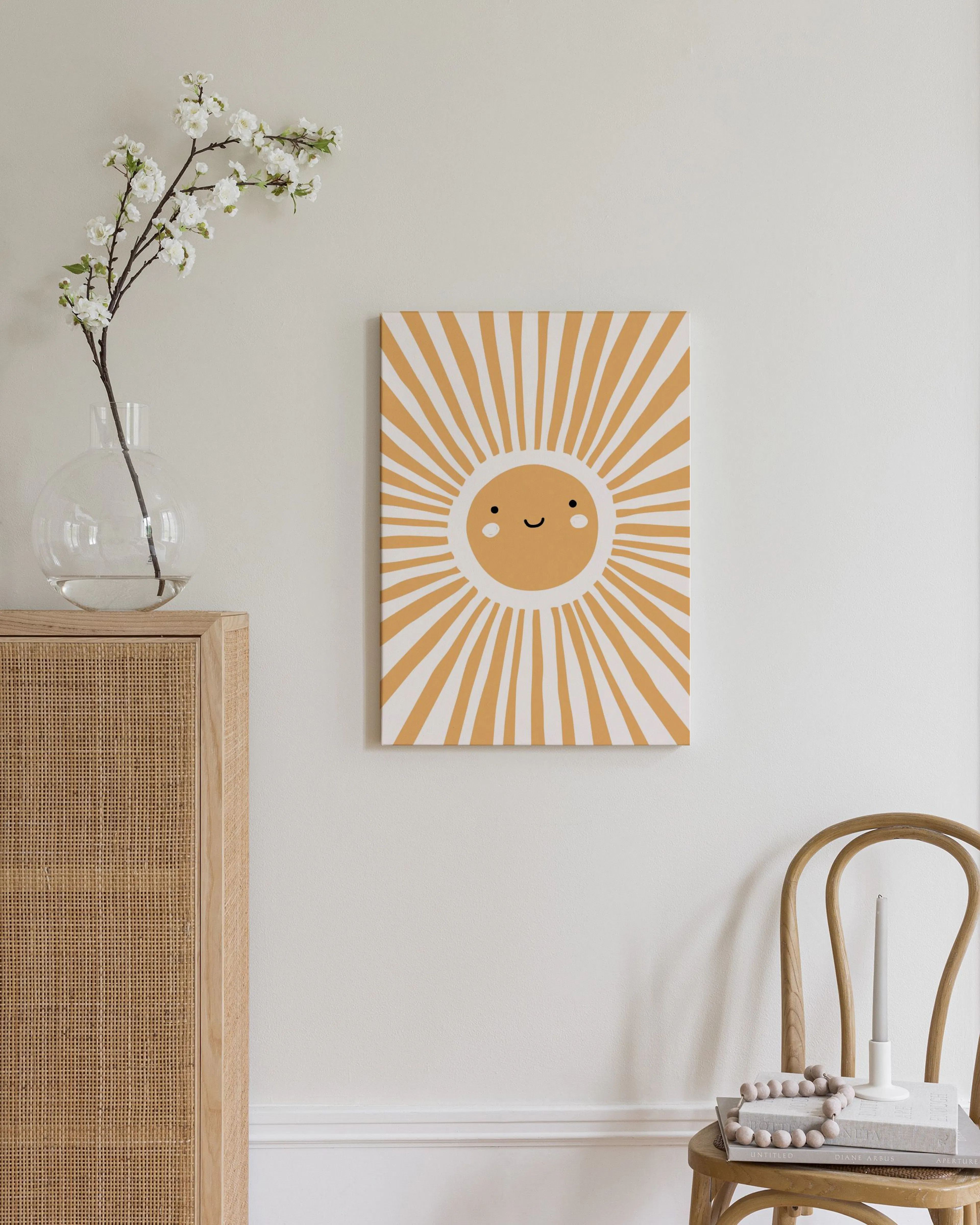 A cheerful sun illustration with a smiling face and radiating yellow and white rays, displayed above a wooden and rattan dresser