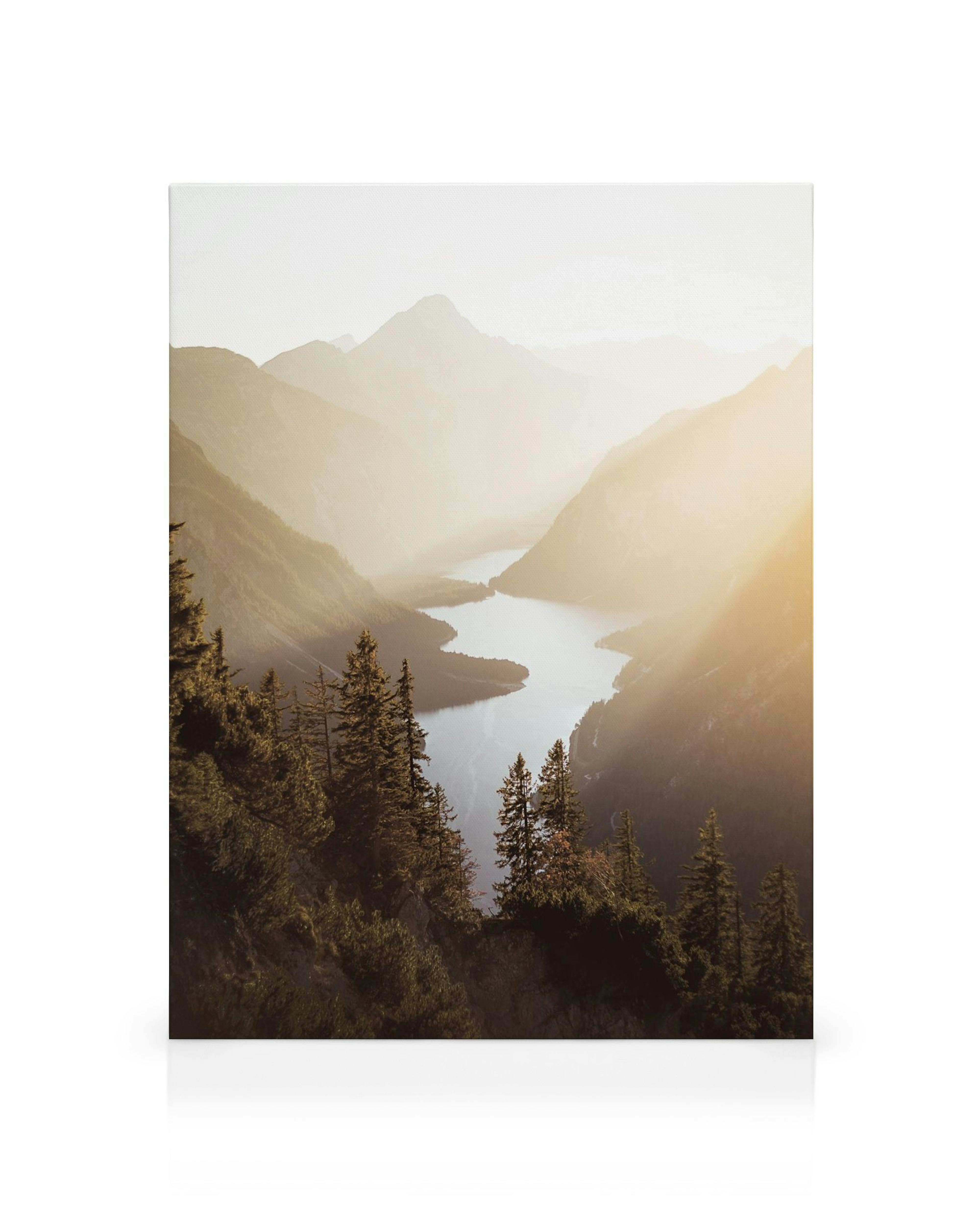 A stunning canvas of a serene lake winding through misty mountain valleys bathed in golden sunlight.