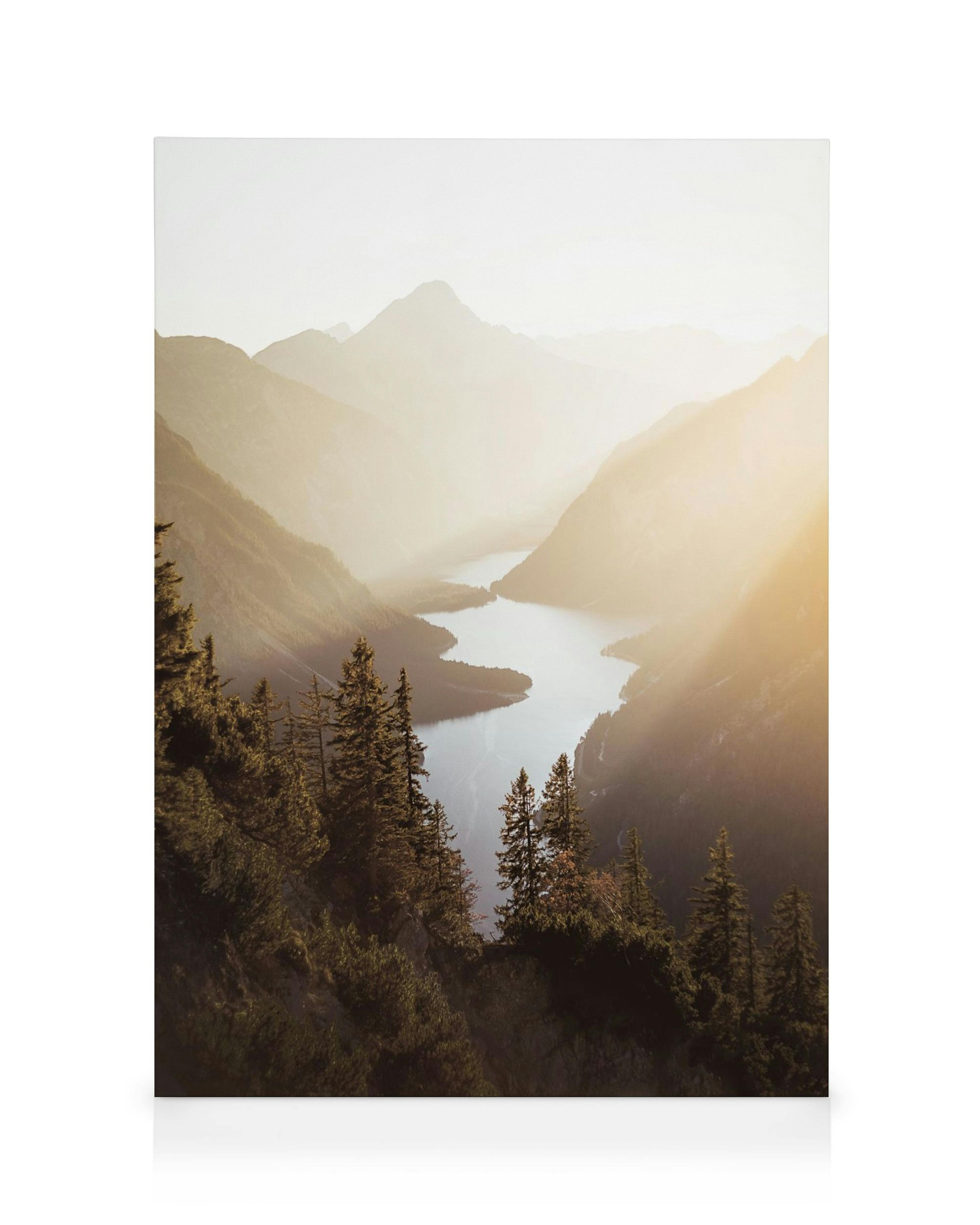 A canvas showing a serene lake winding through misty valleys and mountains, bathed in warm sunset light.