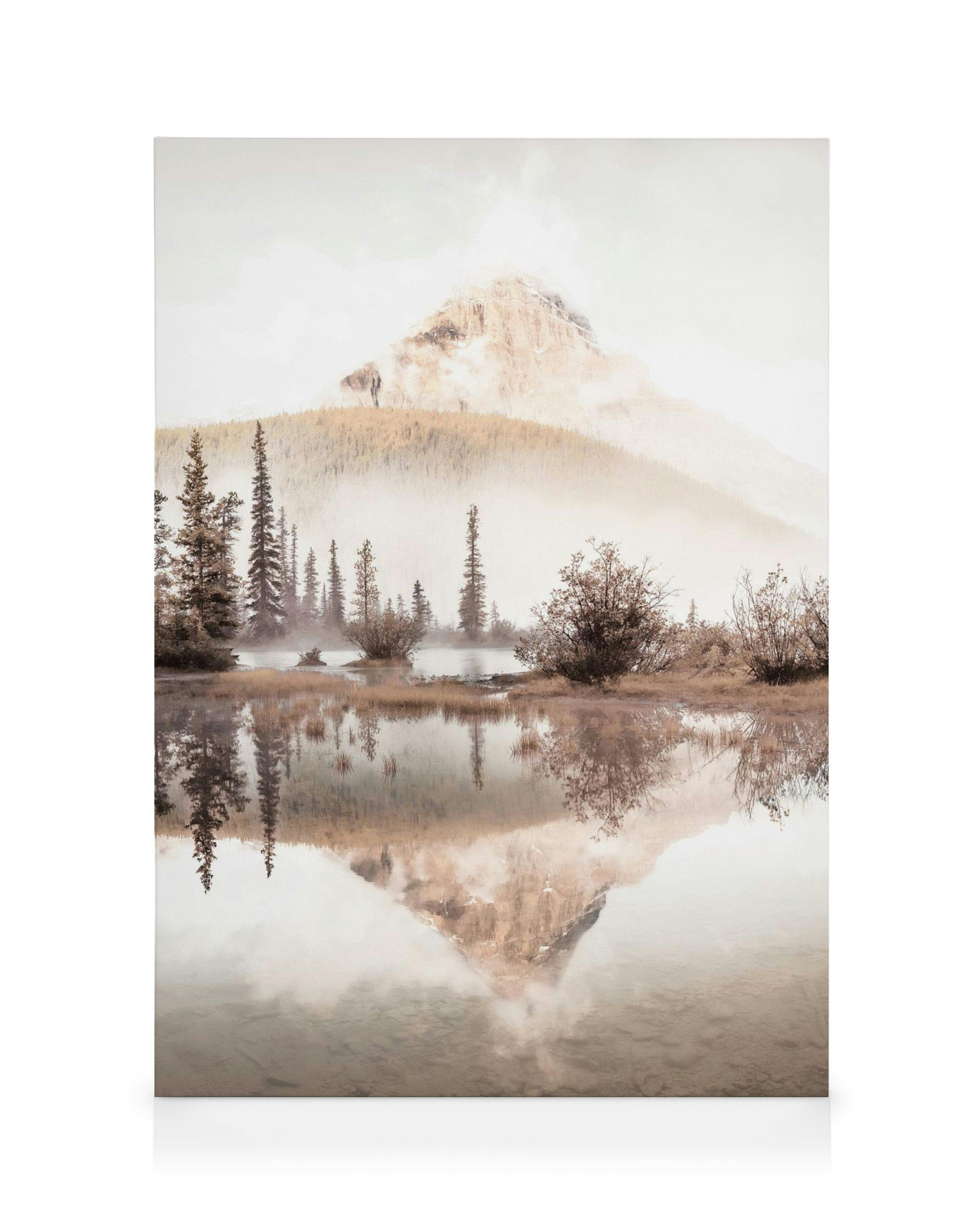Leinwandbild mit einem Berg in Nebelstimmung, umgeben von Bäumen und Büschen, der sich in einem See spiegelt.