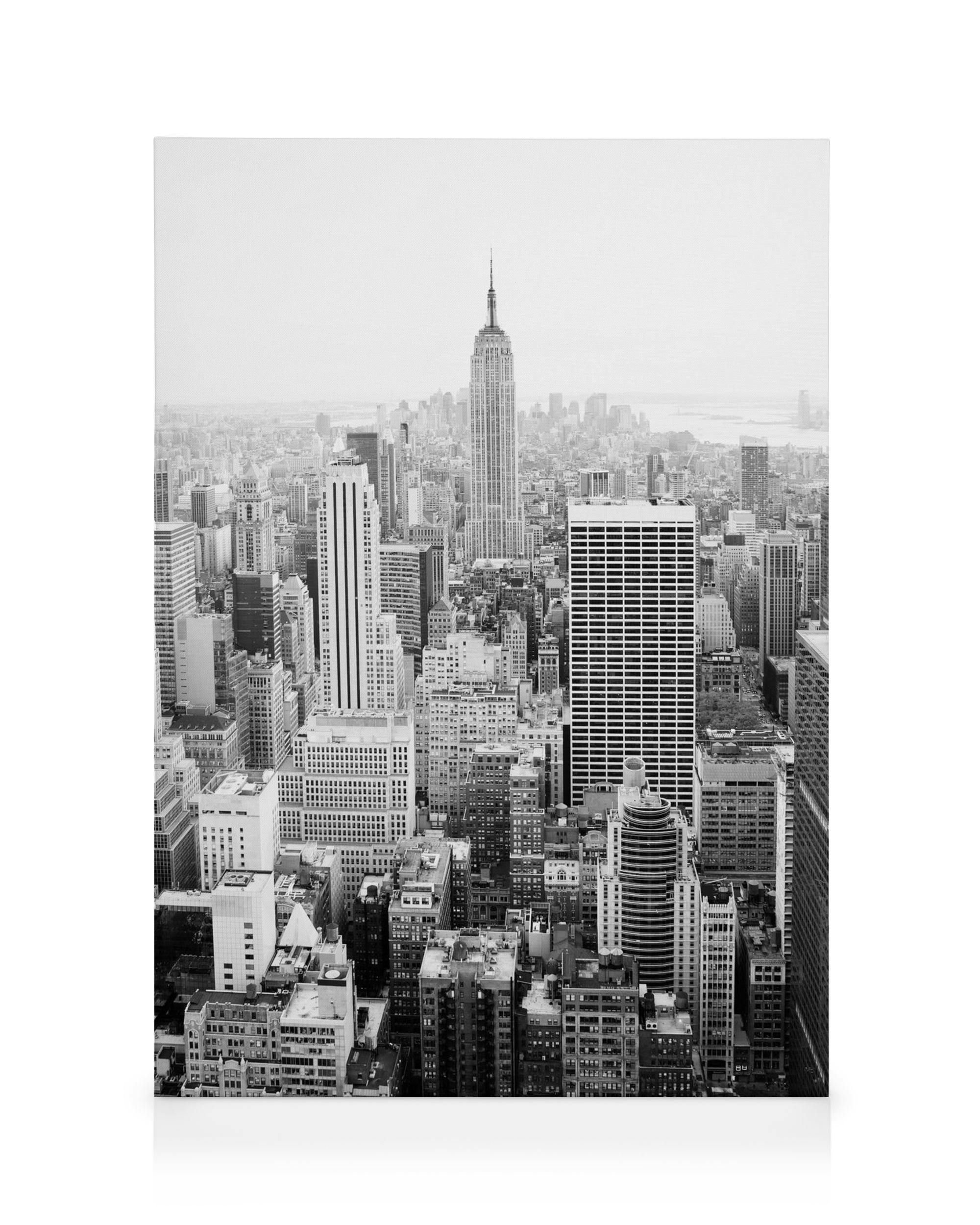 A black and white canvas print showing an aerial view of the New York City skyline with the Empire State Building.