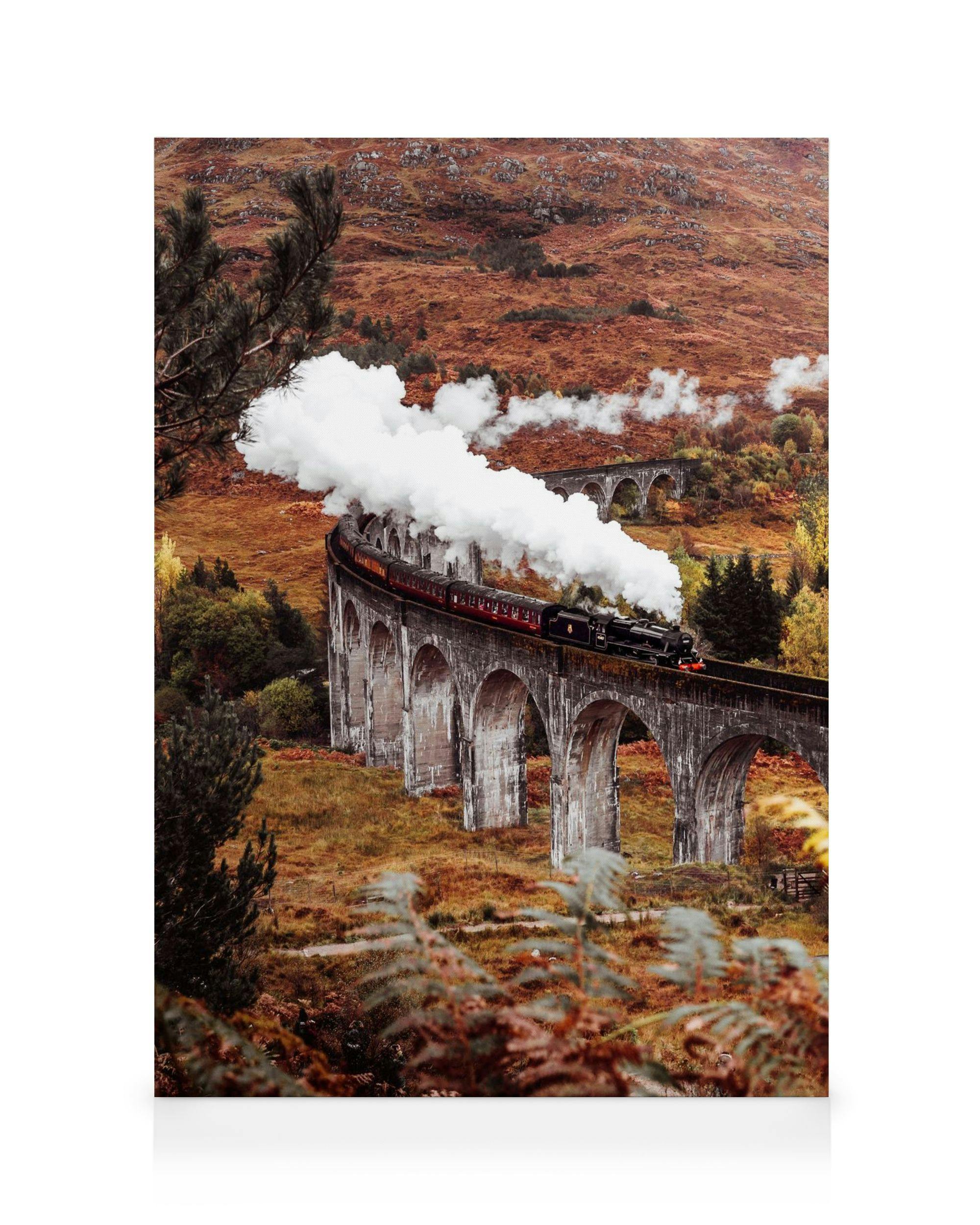A canvas showing a steam train on a stone viaduct in a mountainous landscape with autumn foliage.