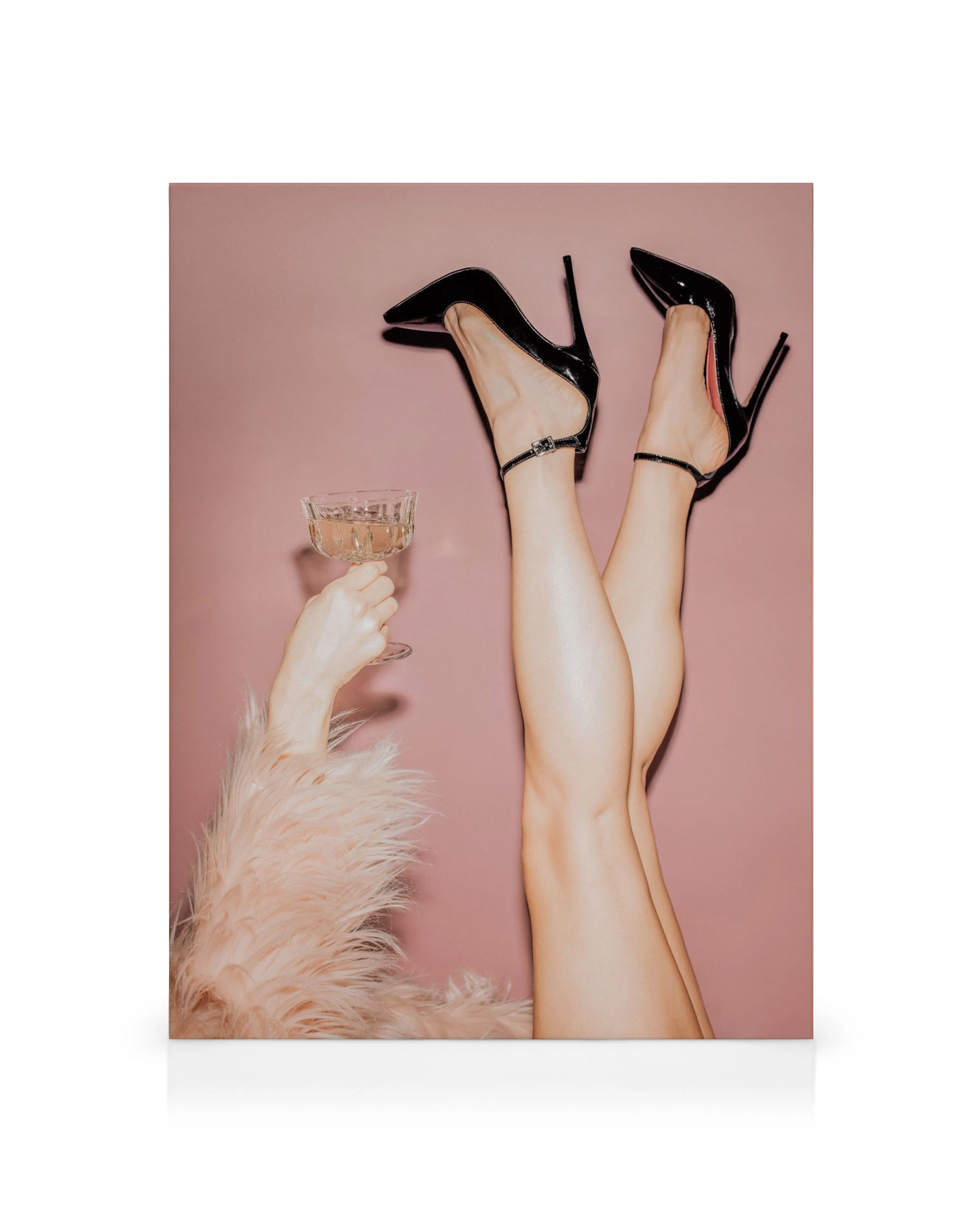 Toile représentant des jambes féminines en talons aiguilles noirs, une main tenant une coupe de champagne, sur fond rose.