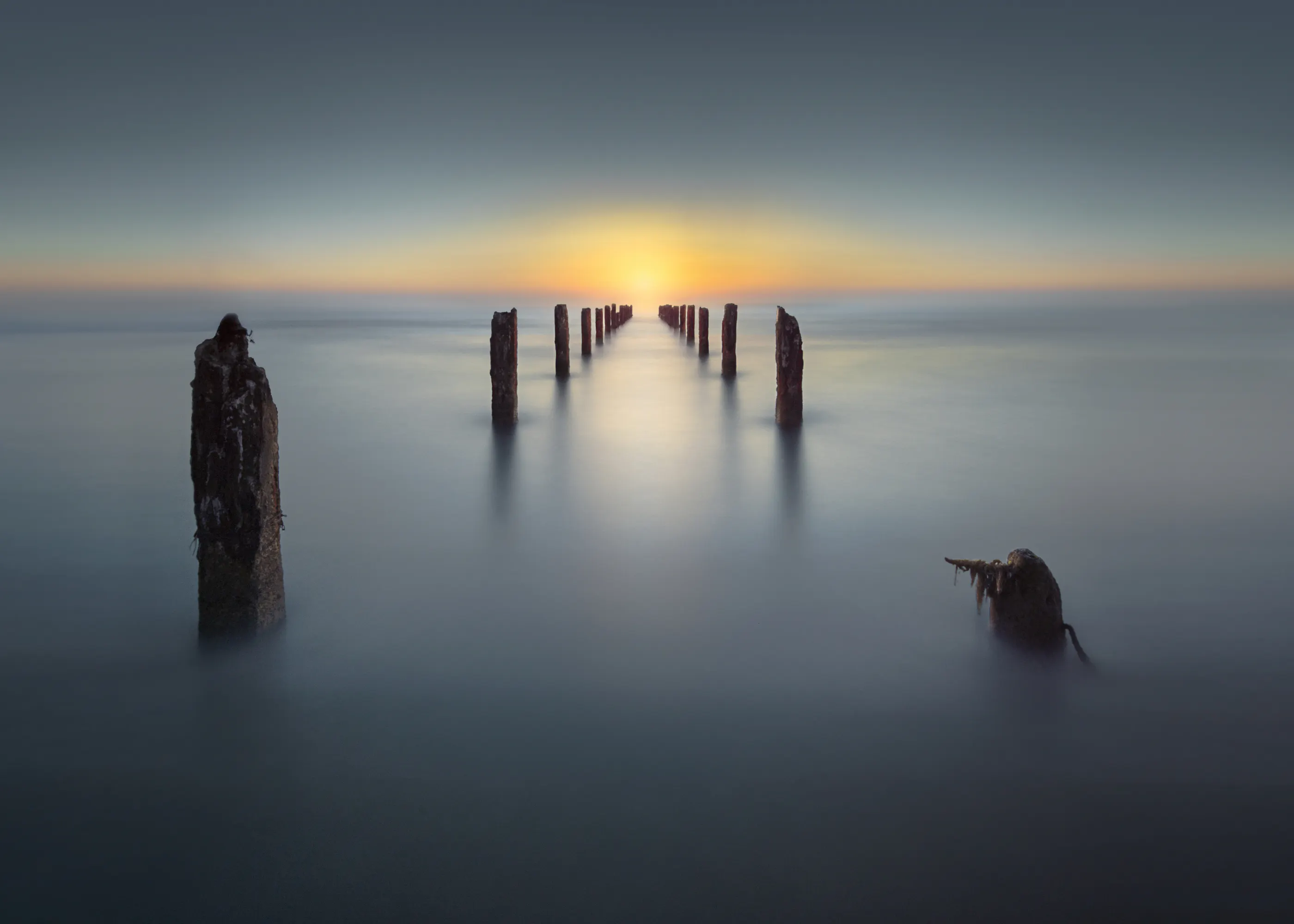 Nadav Jonas - Ocean Pilings Sunset Plakat 0